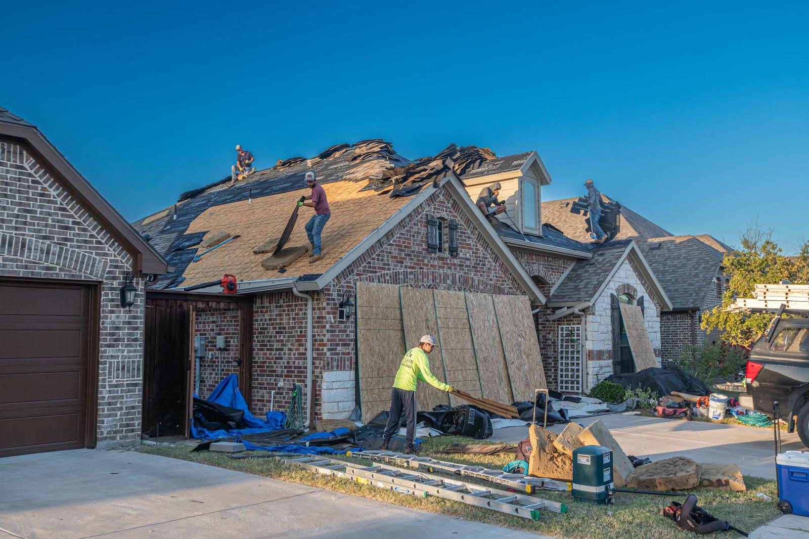 Two roofers working on a residential roof installation